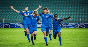 A group of soccer players run together on the field